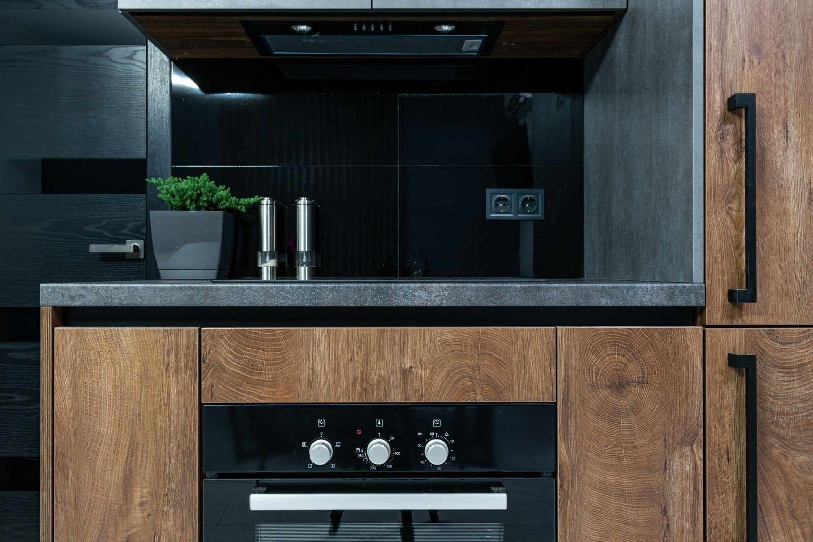 Built in oven in a dark wood and graphite kitchen